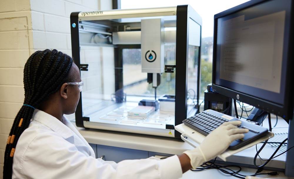 A geneticist engaging in genomic analysis for marker trait association at a compute using genetic laboratory equipment