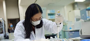 A laboratory scientists working with pcr plates and a pipette for genomic dna analysis