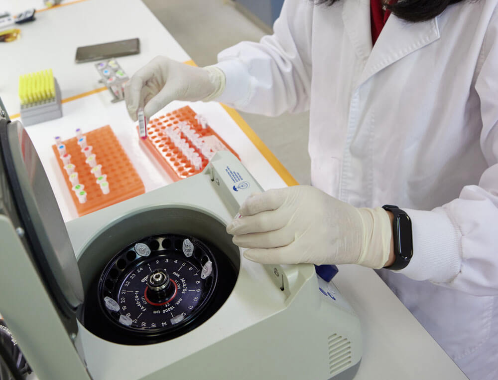 A geneticist assessing plant and seem samples from stacked tubes for DNA analysis